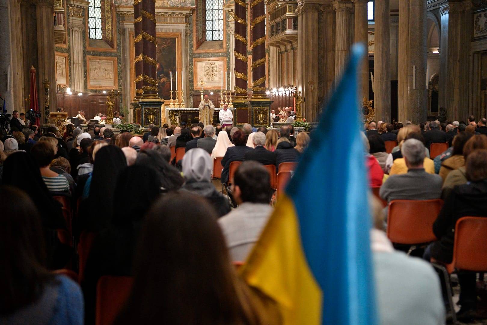 A person holds a Ukrainian flag during a Mass for peace in Ukraine celebrated by Cardinal Pietro Parolin, Vatican secretary of state, Nov. 17, 2022, in Rome's Basilica of St. Mary Major. (Credit: CNS photo/Vatican Media.)